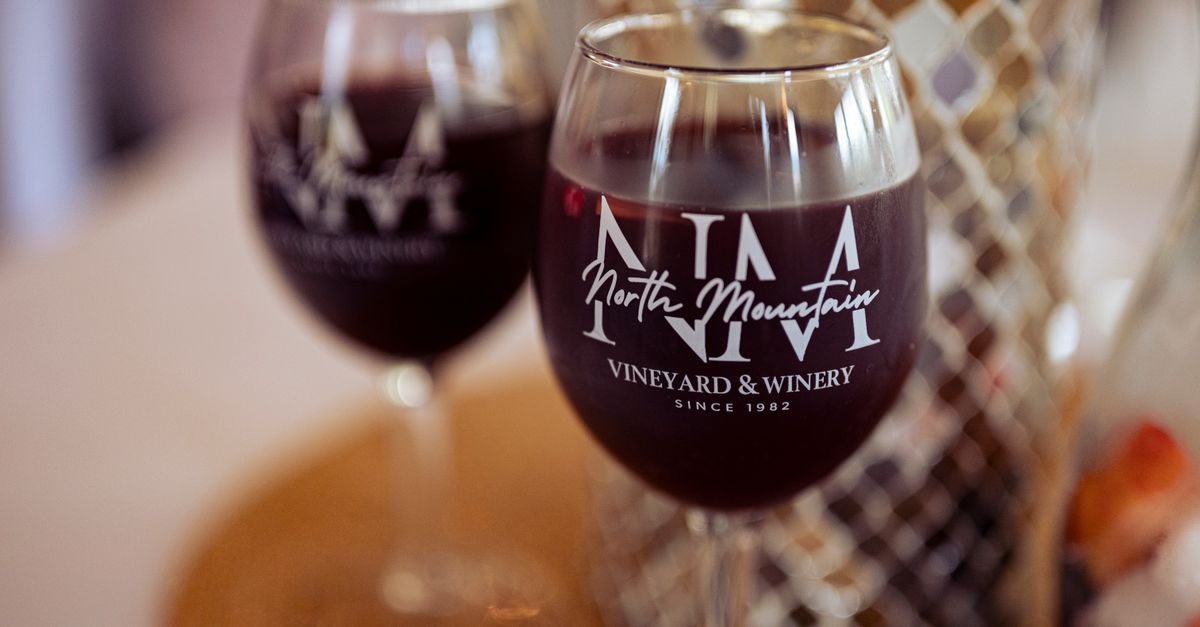 Two glasses of red wine featuring North Mountain Vineyard & Winery logo.